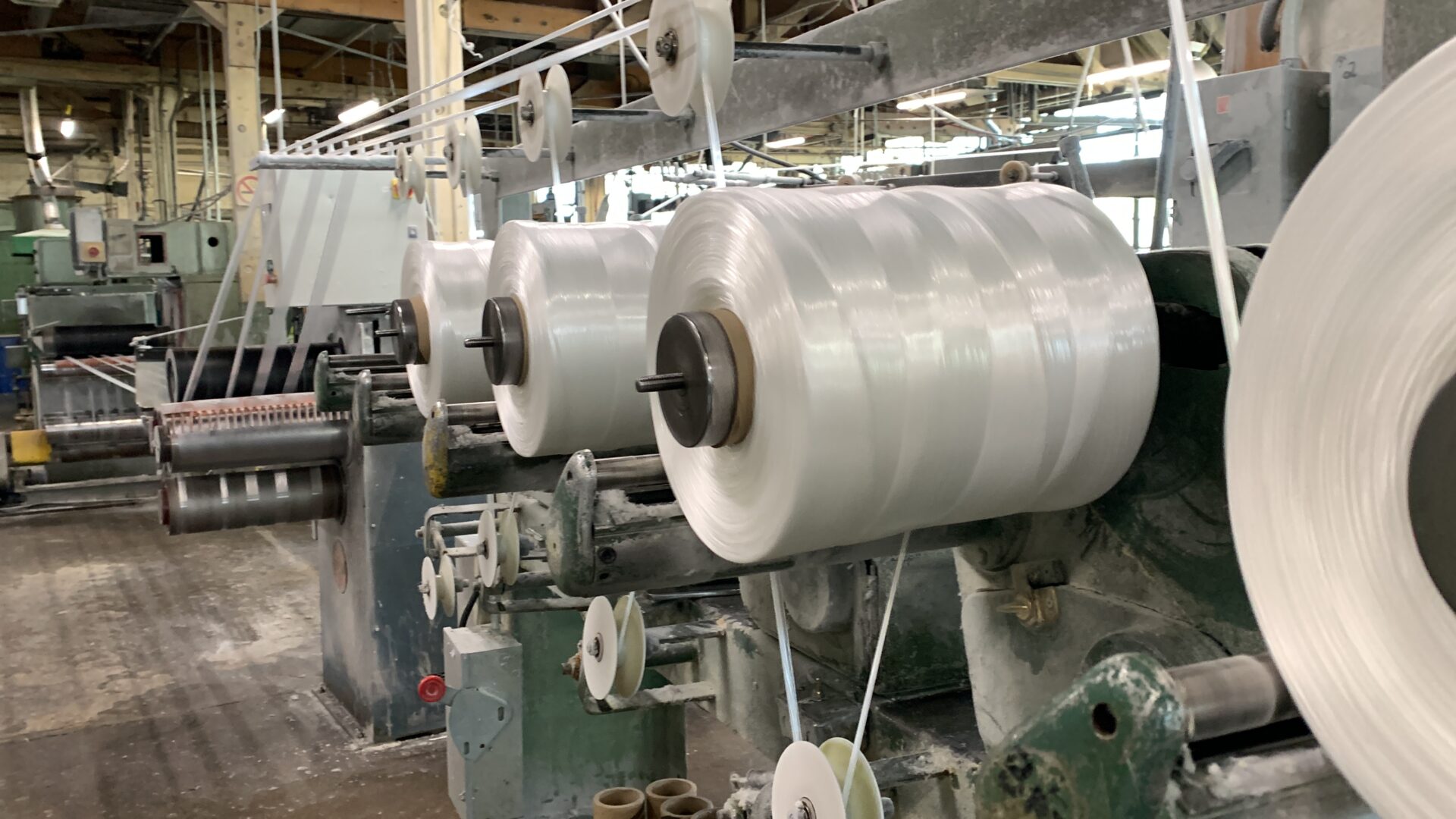 a large industrial factory with numerous loom machines and equipment